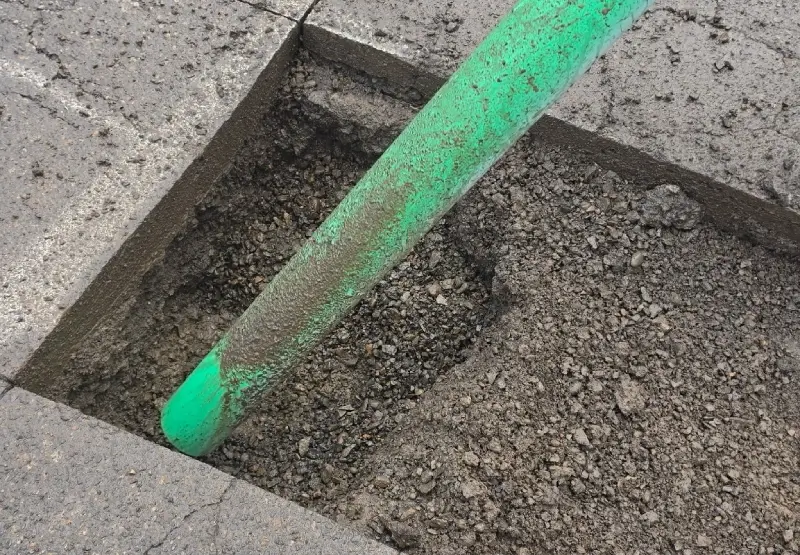 Vacuum excavation hose and equipment next to pothole on Oregon construction site - Prodan Construction