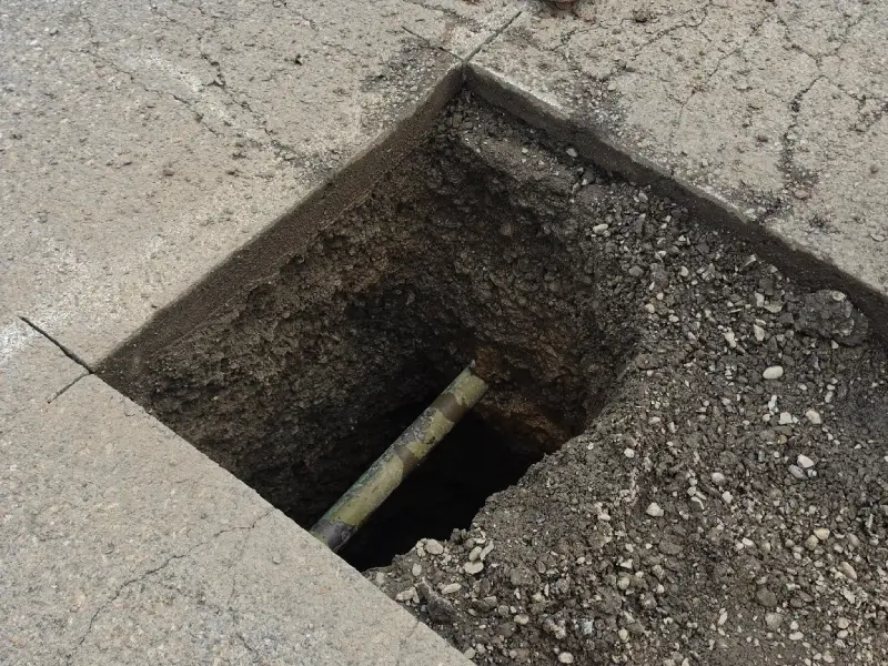 Utility potholing test hole exposing yellow gas pipe underground - Prodan Construction